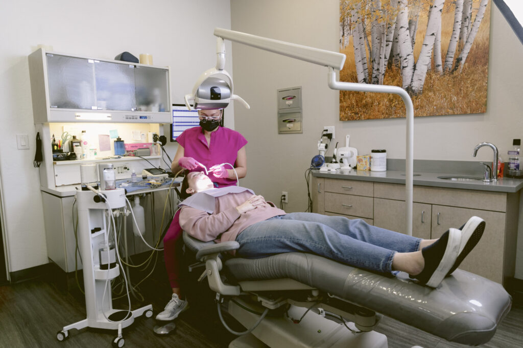 Doctor working on a patient laying in a dentist chair